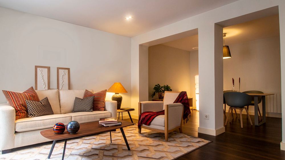 A sunlit living room with a comfortable sofa and warm lamps